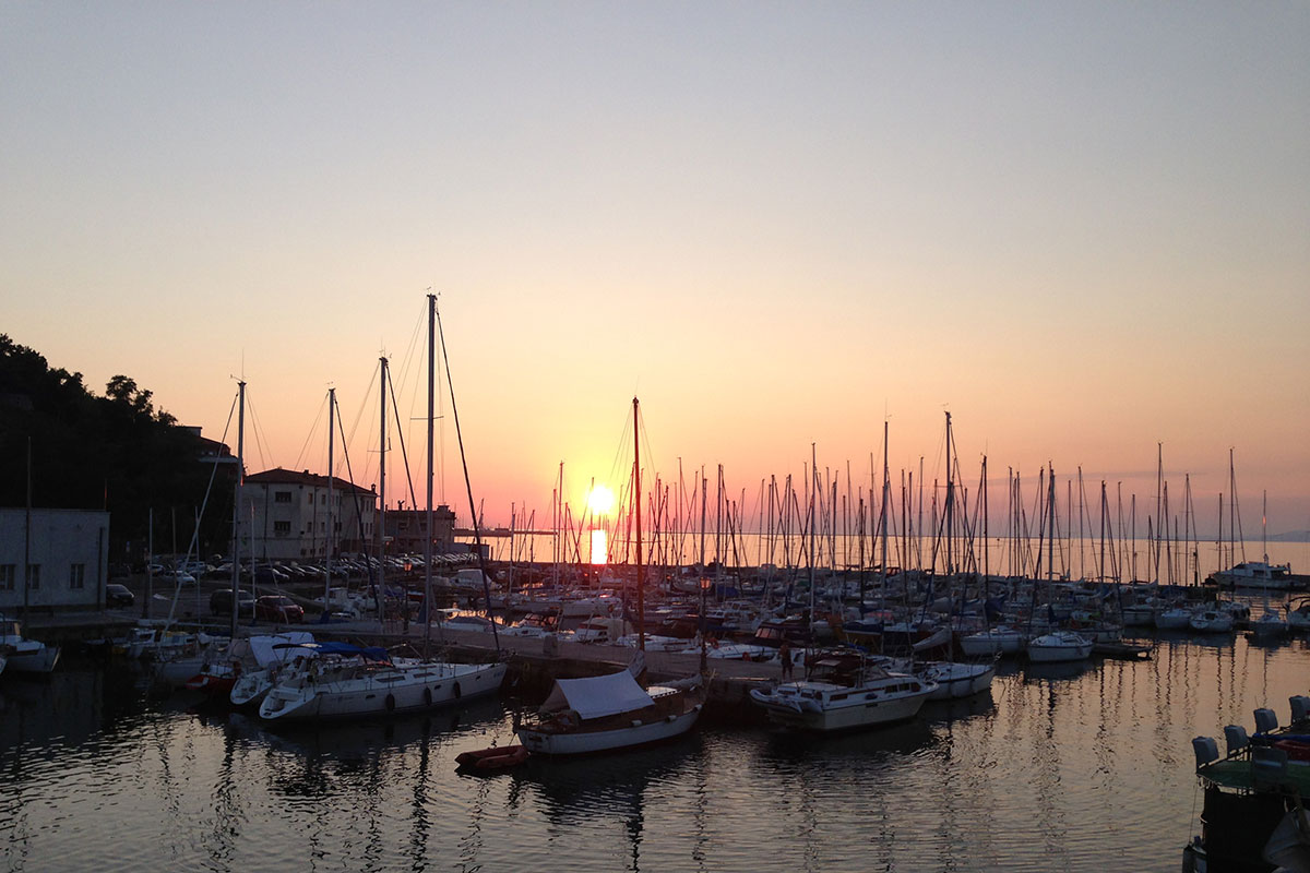 Alpe-Adria-Trail. Sonnenuntergang am Hafen von Muggia