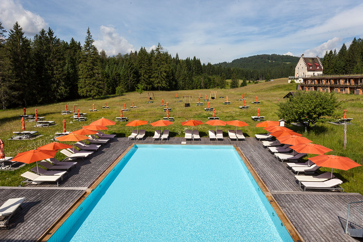 Das Kranzbach – Onsen-Premiere in Oberbayern. Direkt an seinen neuen Onsen grenzt die 130.000 Quadratmeter große Bergwiese, in die im Sommer kleine Inseln für einzeln stehende Liegen und Sonnenschirme gemäht werden