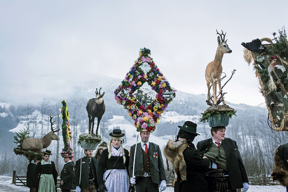 Rauhnächte – Die Dämonen-Vertreiber. Alle Jahre wieder: Aufstellung zum Gasteiner Perchtenlauf. Die Trapezkappe wurde 1994 neu gebaut und hat vier Spiegel an der Vorderseite, Hirsch, Reh und Gams symbolisieren die drei wichtigsten Gasteiner Wildtiere und den Bezug zur Jagd. Die Kappen wiegen bis zu 50 Kilogramm und erreichen eine Höhe von bis zu 2,50 Meter