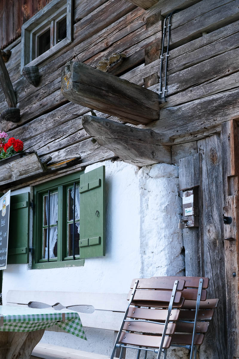 Die Fenster der Alm blicken fröhlich in in die Landschaft.