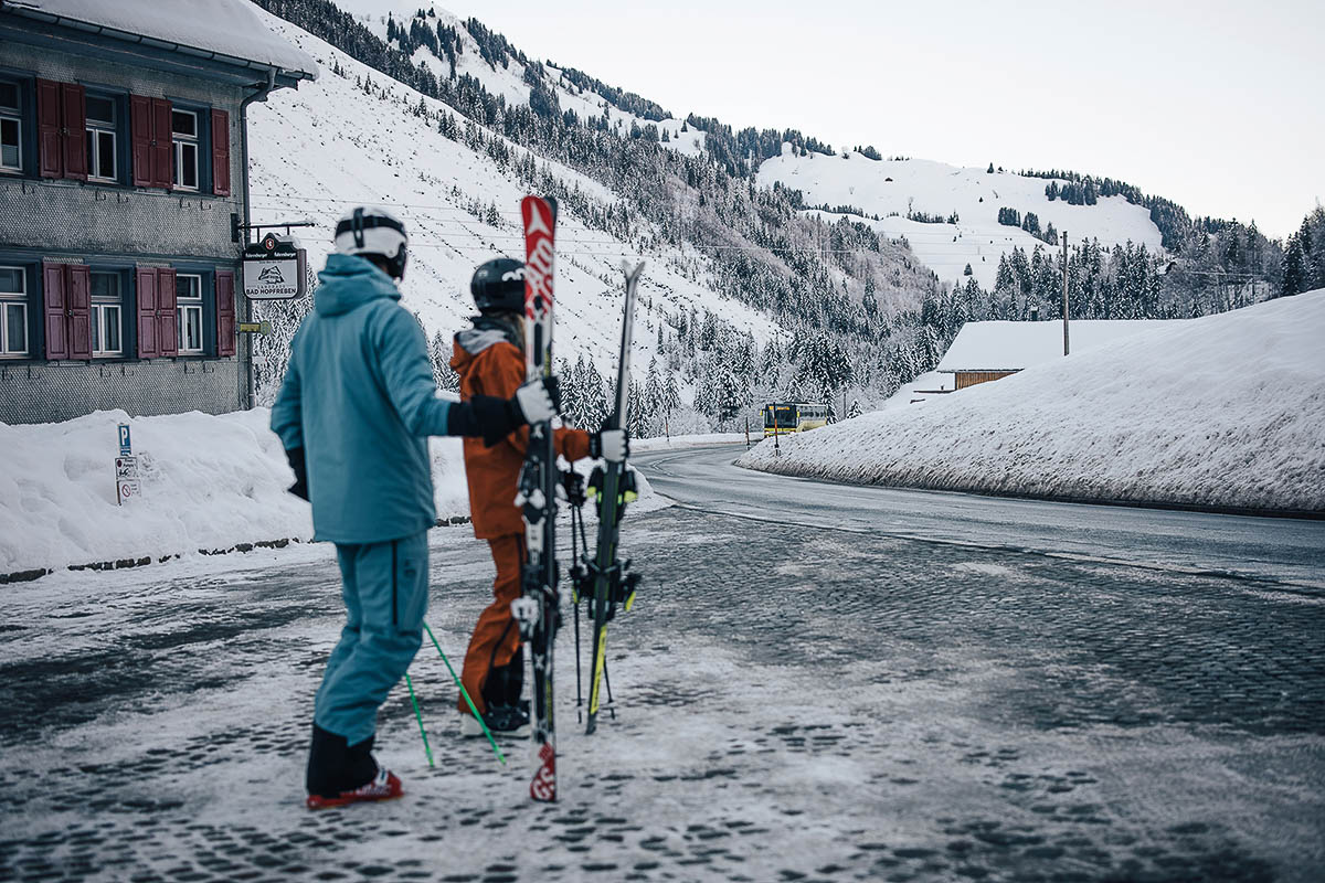 Skifahrer warten mit Skiausrüstung auf den Skibus in Warth-Schröcken am Arlberg