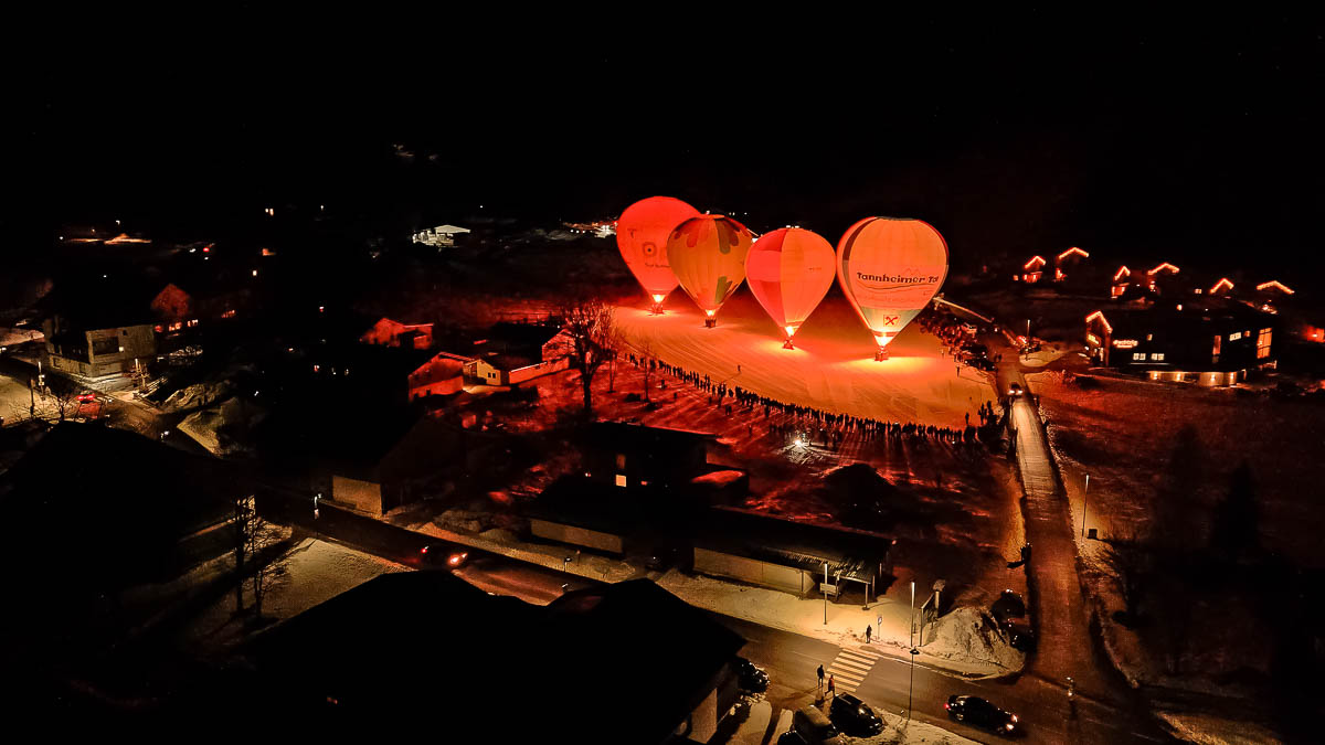 Beim Ballonglühen leuchten die Hüllen der Heißluftballone und setzen einen stimmungsvollen Akzent im winterlichen Tannheimer Tal.