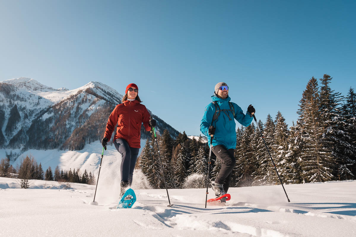 Zwei Menschen beim Schneeschuhwandern durch unberührte Winterlandschaft im Pillerseetal
