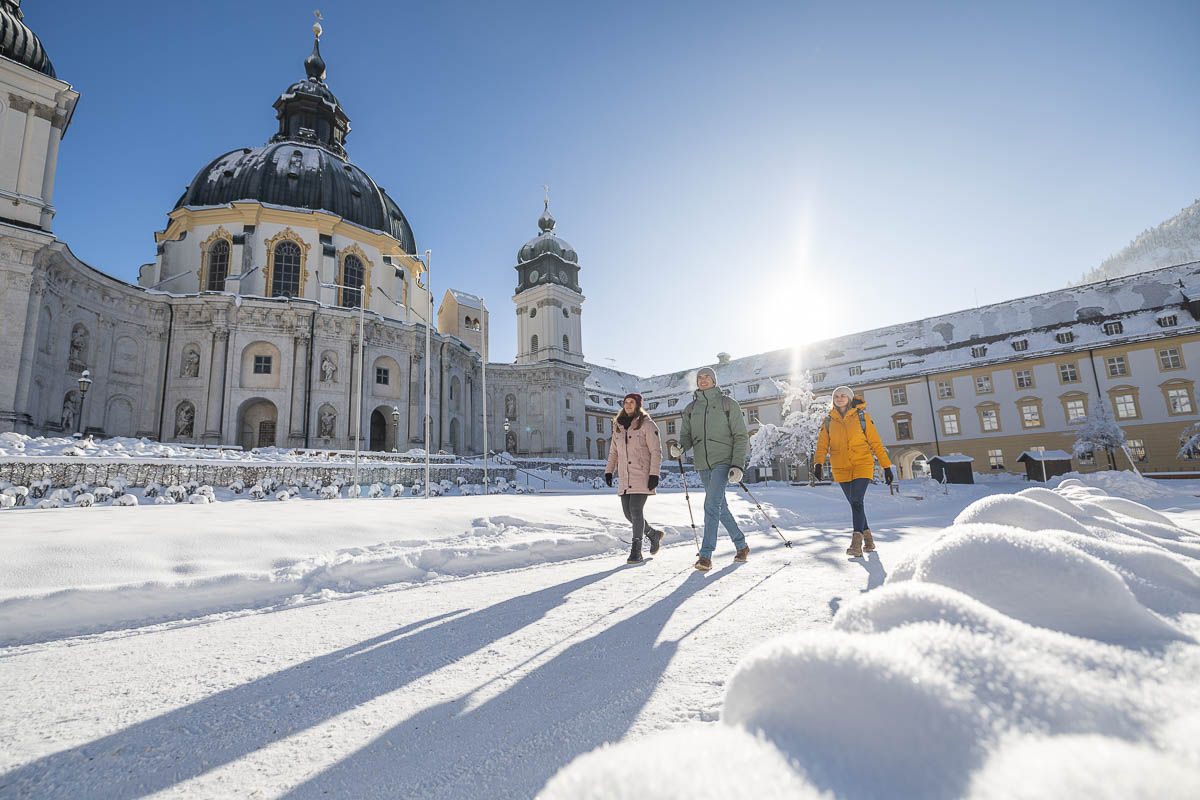 Winterwanderer vor der Basilika des Klosters Ettal in Bayern.