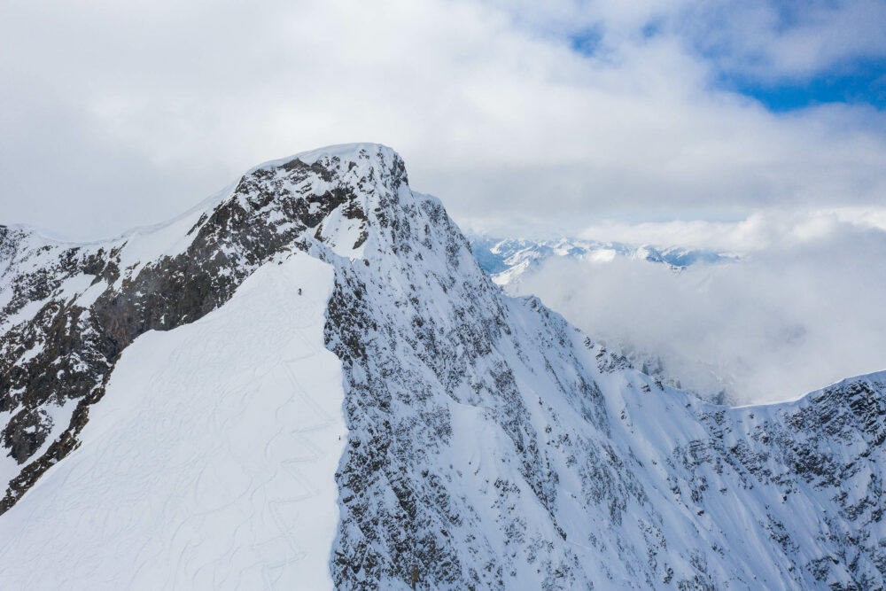 Skialpinist am schmalen Grat oberhalb einer 45 Grad steilen Flanke am Larmkogel in den Hohen Tauern.