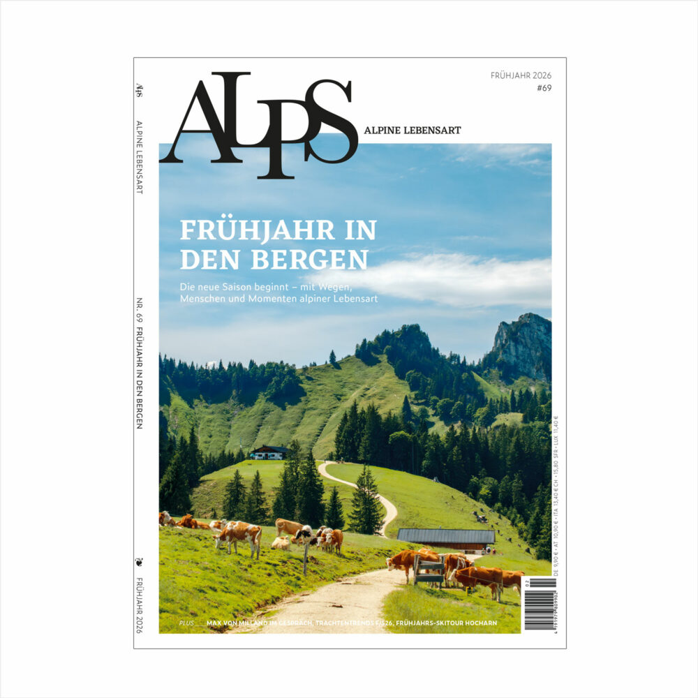 Frühling in den Alpen mit grünen Wiesen, Kühen und Berglandschaft – Cover des ALPS Magazins Ausgabe 69