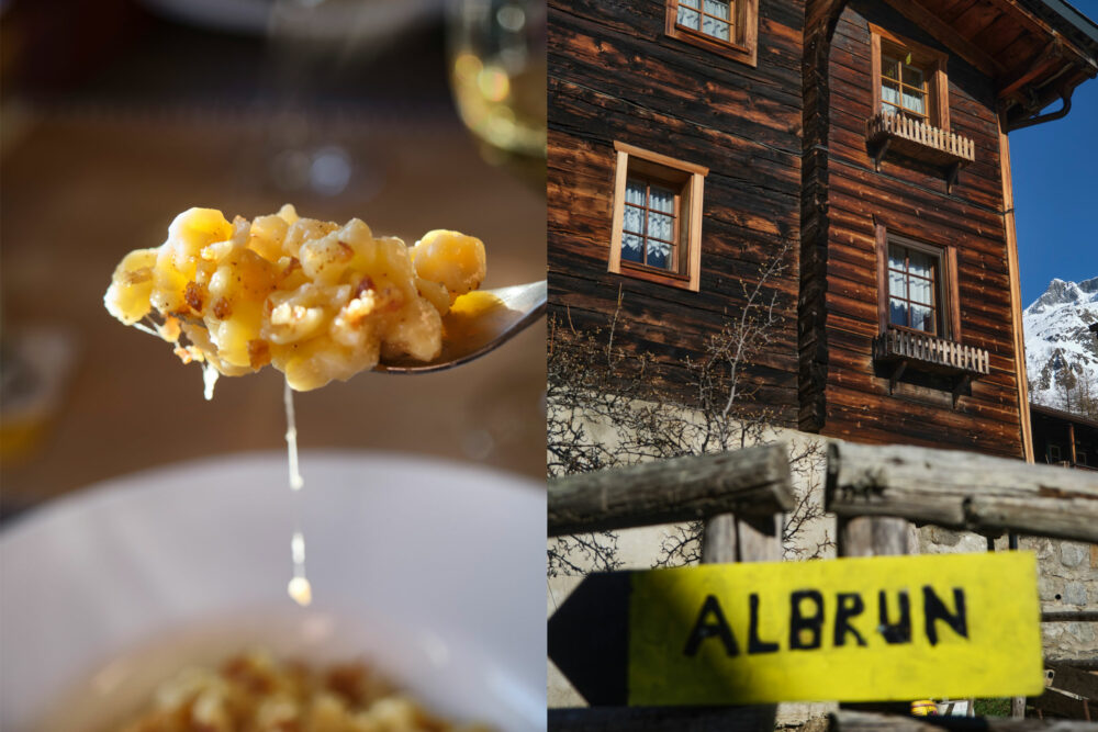 Käsespätzle auf einem Löffel vor Walliser Holzhaus und Wegweiser zum Albrunpass bei der Skidurchquerung zwischen Wallis und Piemont