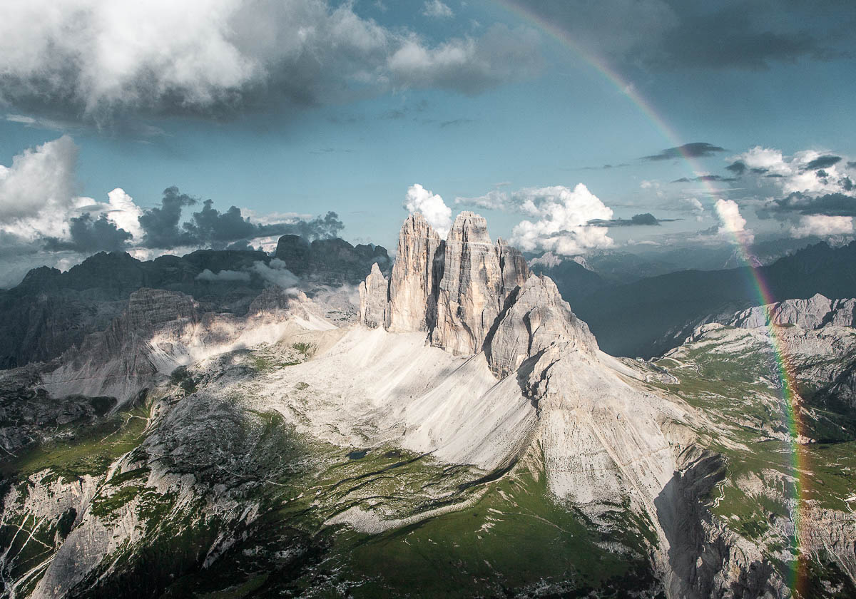 Luftaufnahme der Drei Zinnen in den Dolomiten mit Regenbogen