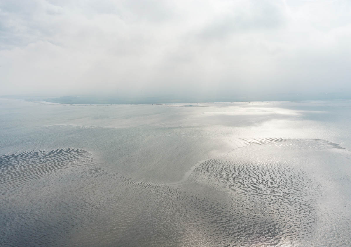 Weite Landschaft des Wattenmeers mit Nebel und feinen Sandstrukturen