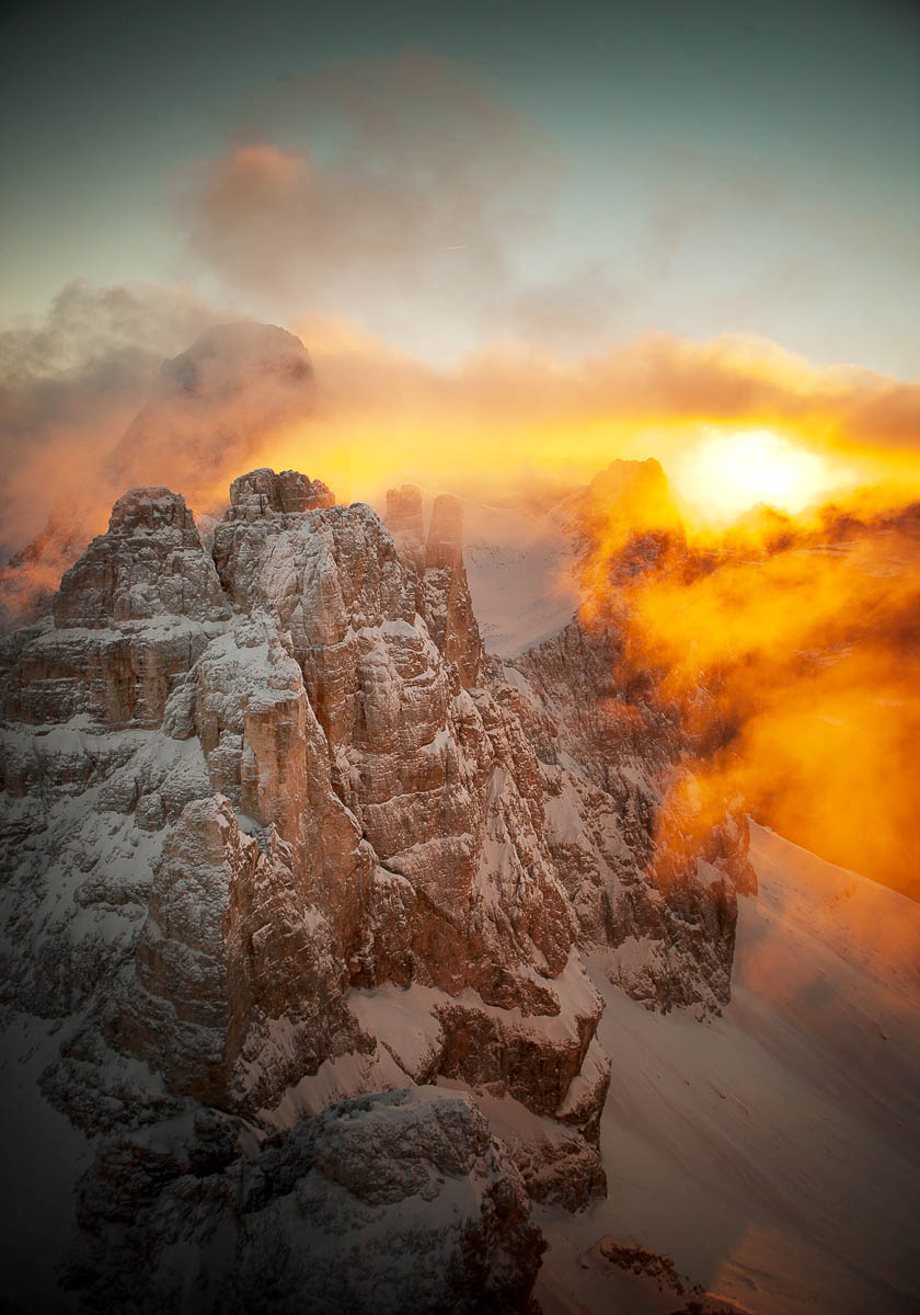 Dolomiten-Gipfel im warmen Licht des Sonnenaufgangs mit dramatischen Wolken