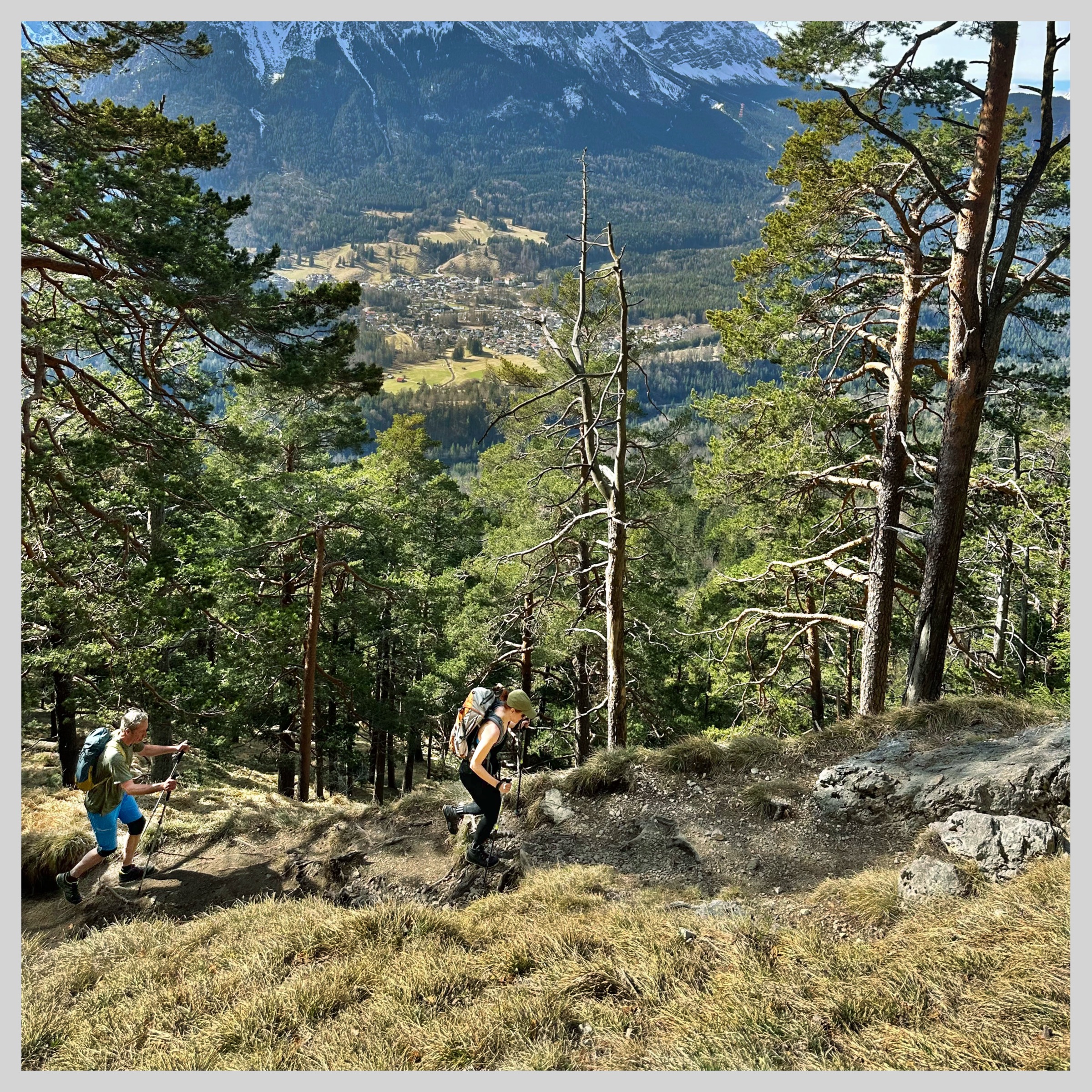 Wanderer beim Aufstieg auf den Hirschbichel oberhalb von Garmisch-Partenkirchen mit Blick ins Tal