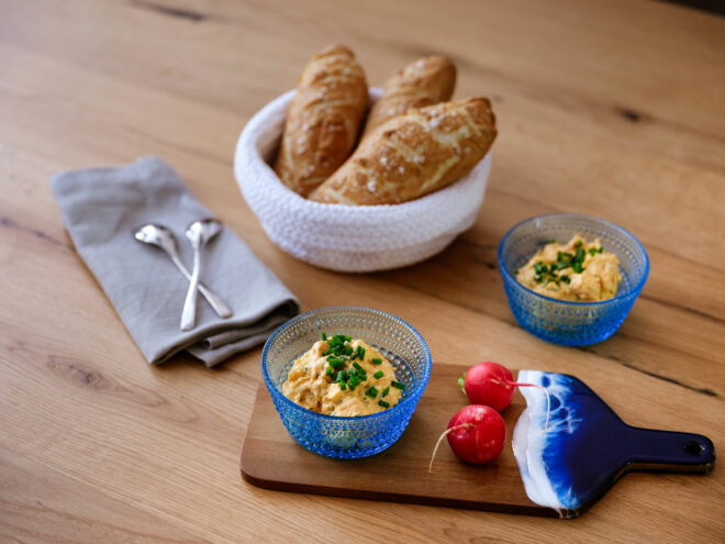 Klassischer bayerischer Obazda mit Schnittlauch und Brezn auf rustikalem Holztisch serviert