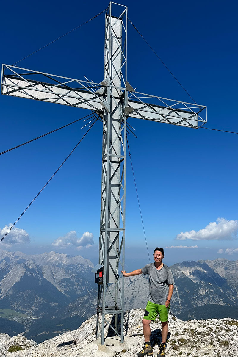 Enno Kapitza steht am großen Gipfelkreuz des 2.492 Meter hohen Hohen Gleirsch im Karwendel.