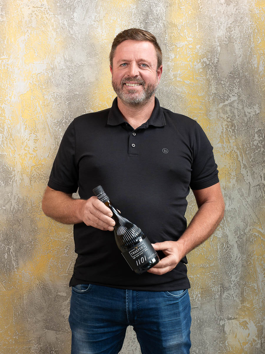 Peter Somweber vom Trueferhof in Ehrwald mit einer Flasche TRUEFER’S Wein